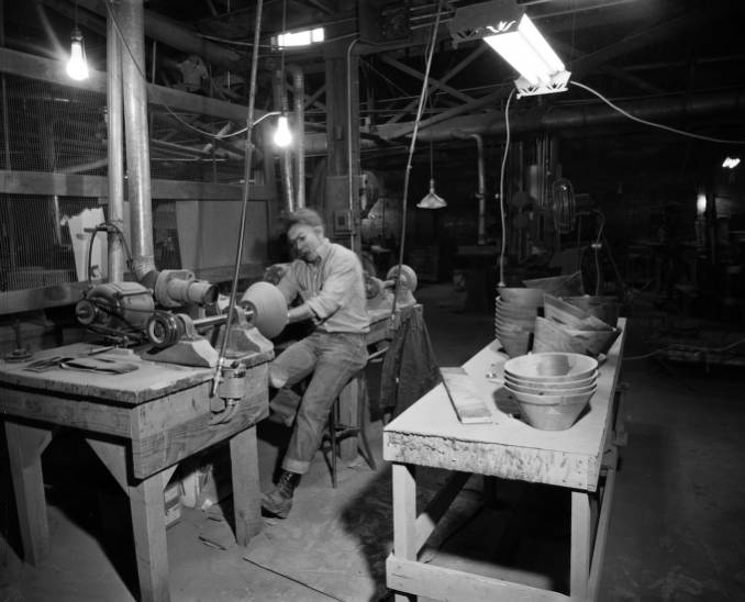 Craftsperson turning wood on a lathe in a 1960s workshop